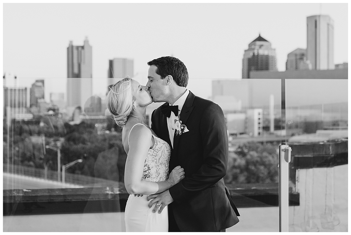 Bride and groom kissing on rooftop at Revery reception in Columbus, Ohio photographed by Ashleigh Grzybowski an Ohio wedding photographer