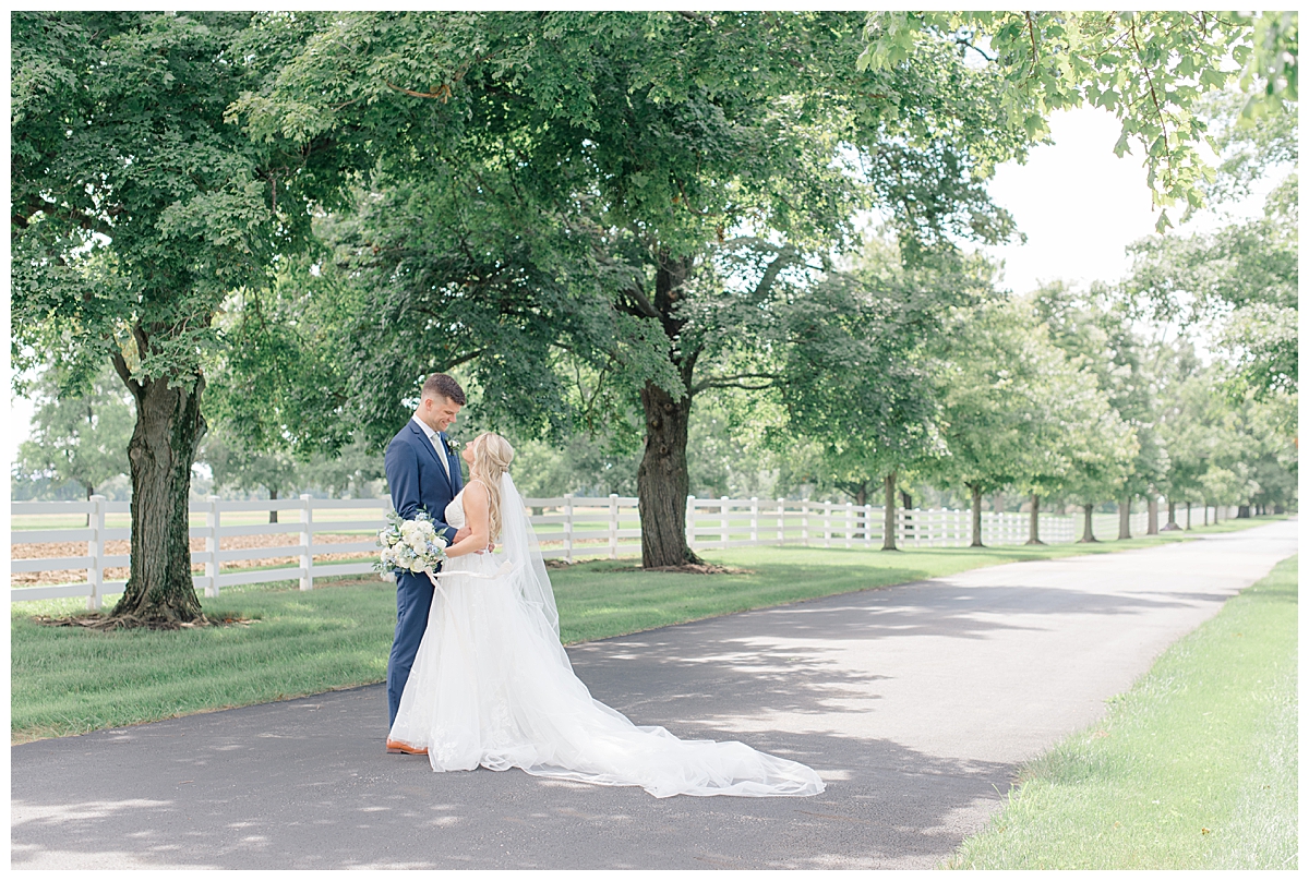 bride and groom smiling on tree line drive at darby house in columbus, ohio