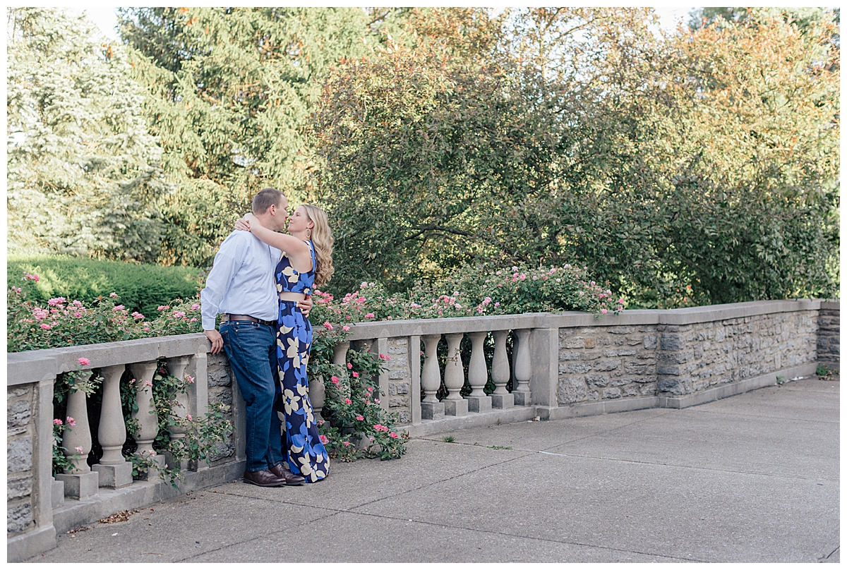 engaged couple hugging by roses in ault park during a Cincinnati ohio engagement session photographed by ashleigh grzybowski a Cincinnati ohio wedding photographer