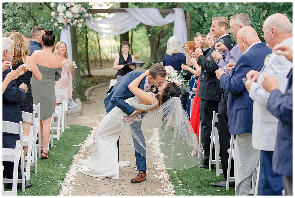 Groom dipping bride after ceremony at Brookshire event venue in Columbus, Ohio taken by Ashleigh Grzybowski an Ohio Wedding Photographer