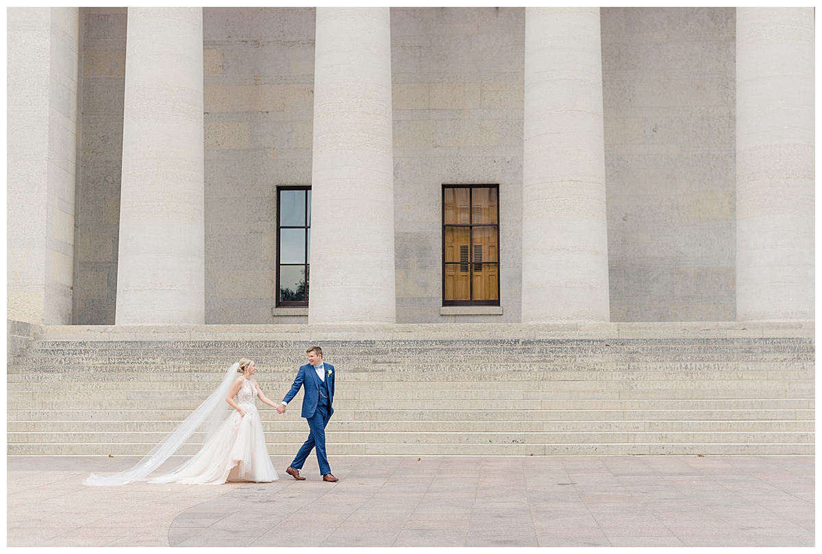 Bride and groom walking in front of Ohio State House a wedding venue in Columbus, Ohio taken by Ashleigh Grzybowski an Ohio wedding photographer