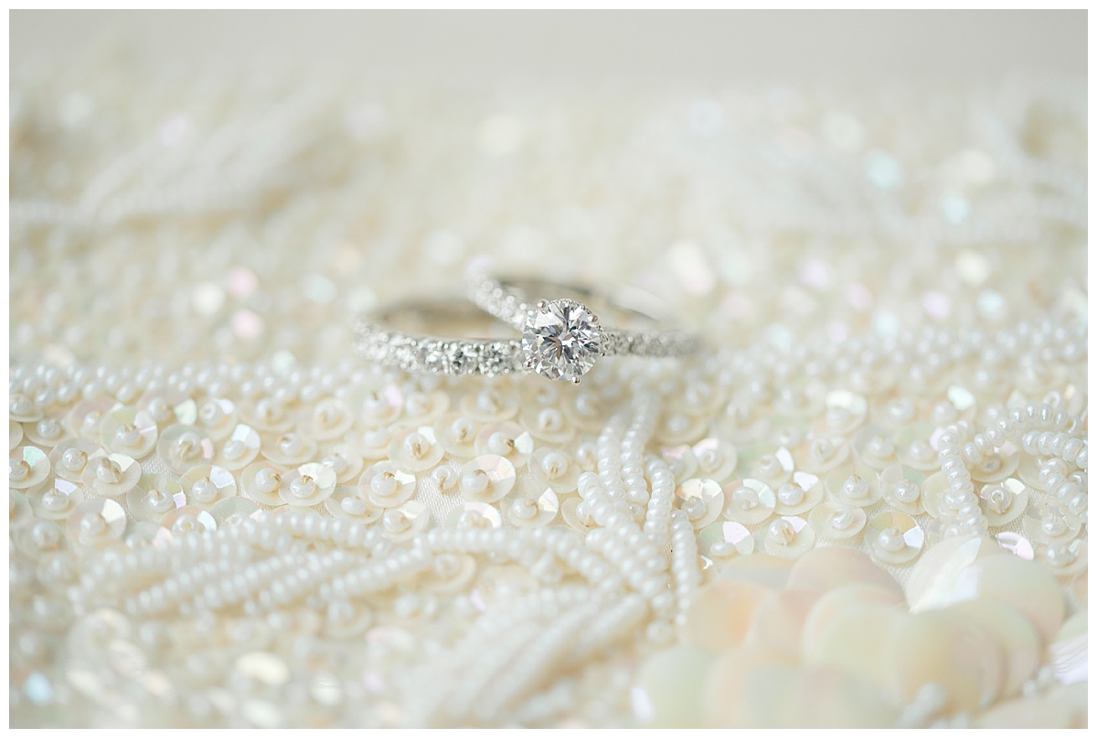 bride's rings on top of wedding clutch