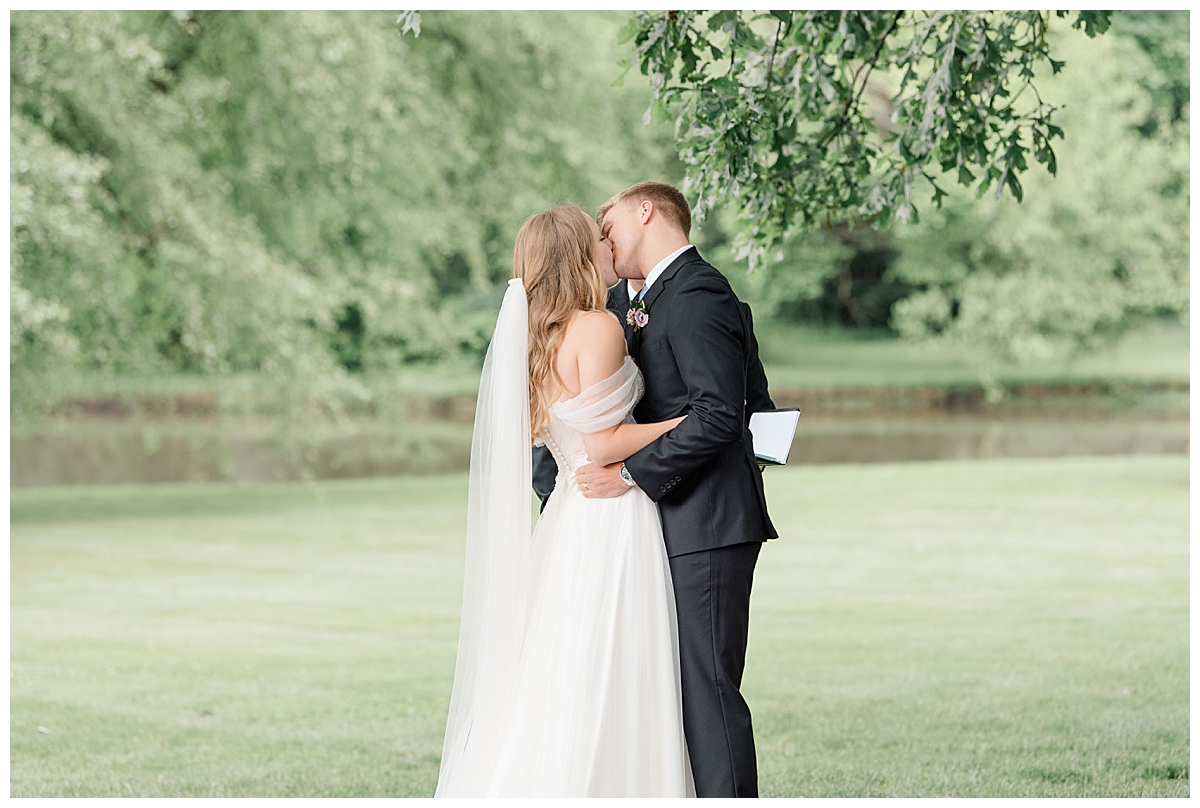 Groom and bride kissing at wedding ceremony at Columbus, Ohio wedding taken by Ashleigh Grzybowski an Ohio Wedding Photographer