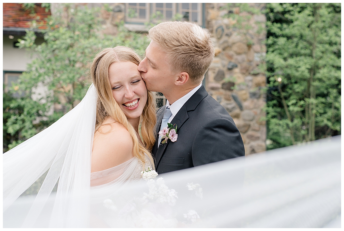 Groom kissing bride at Beverly Mansion wedding in Columbus, Ohio taken by Ohio Wedding Photographer Ashleigh Grzybowski