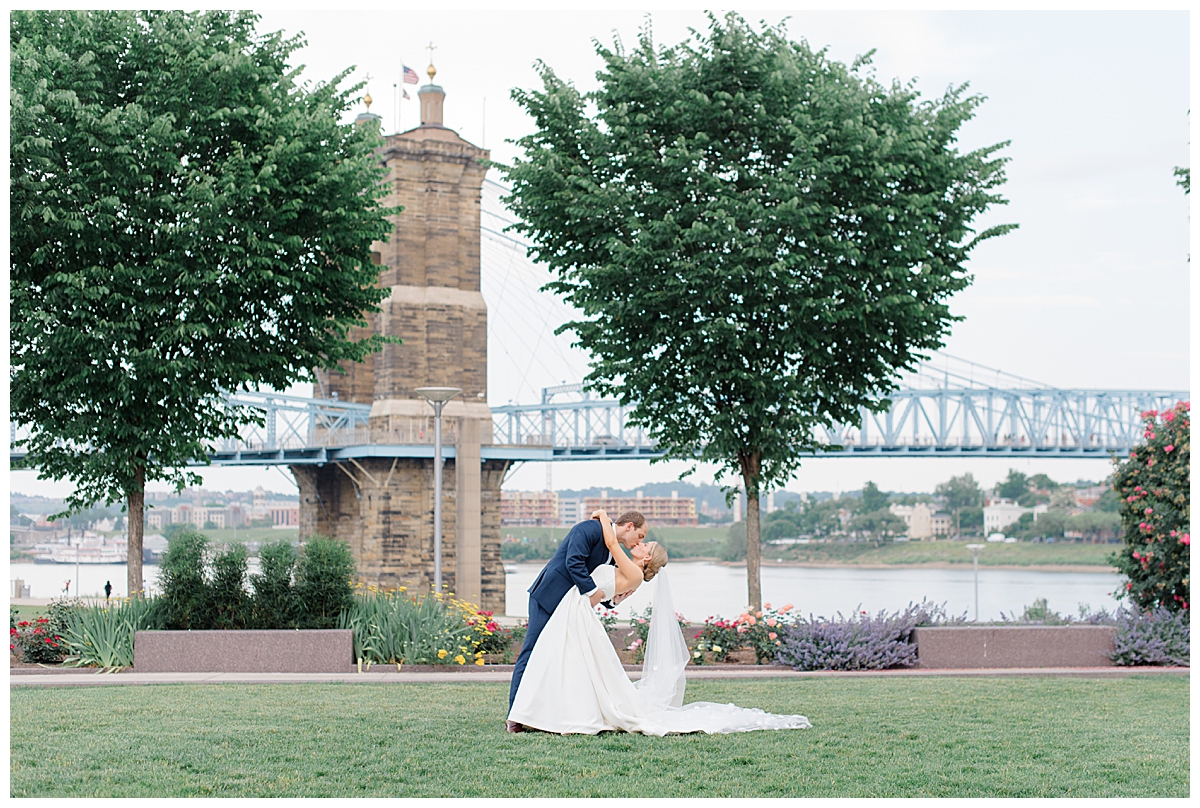Groom dipping bride on ohio river front in cincinnati, ohio at anderson pavilion wedding photographed by columbus, wedding photographer
