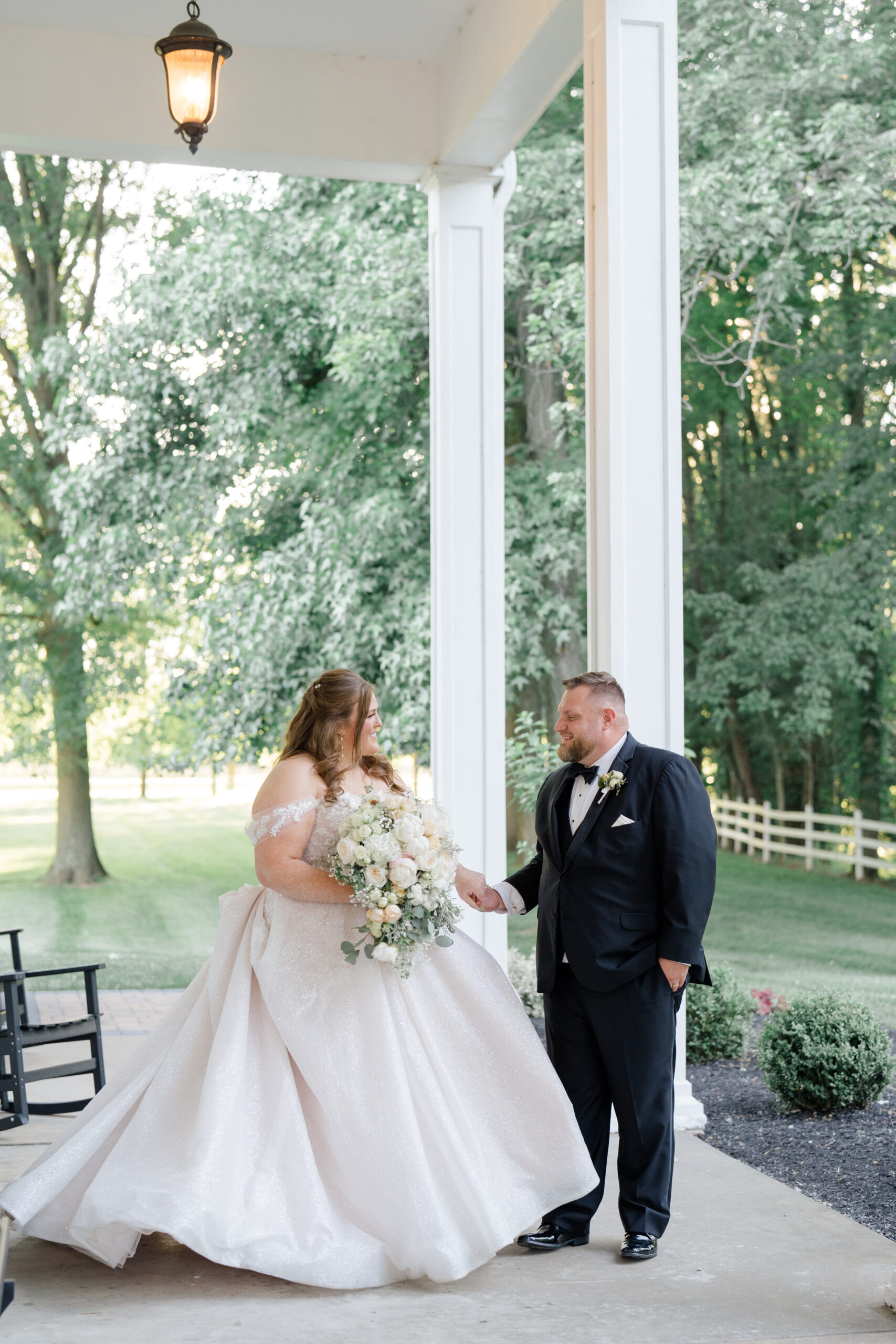 Columbus wedding photographers captures bride and groom holding hands and walking together on the front porch of Mount Vernon Estates Events wedding venue