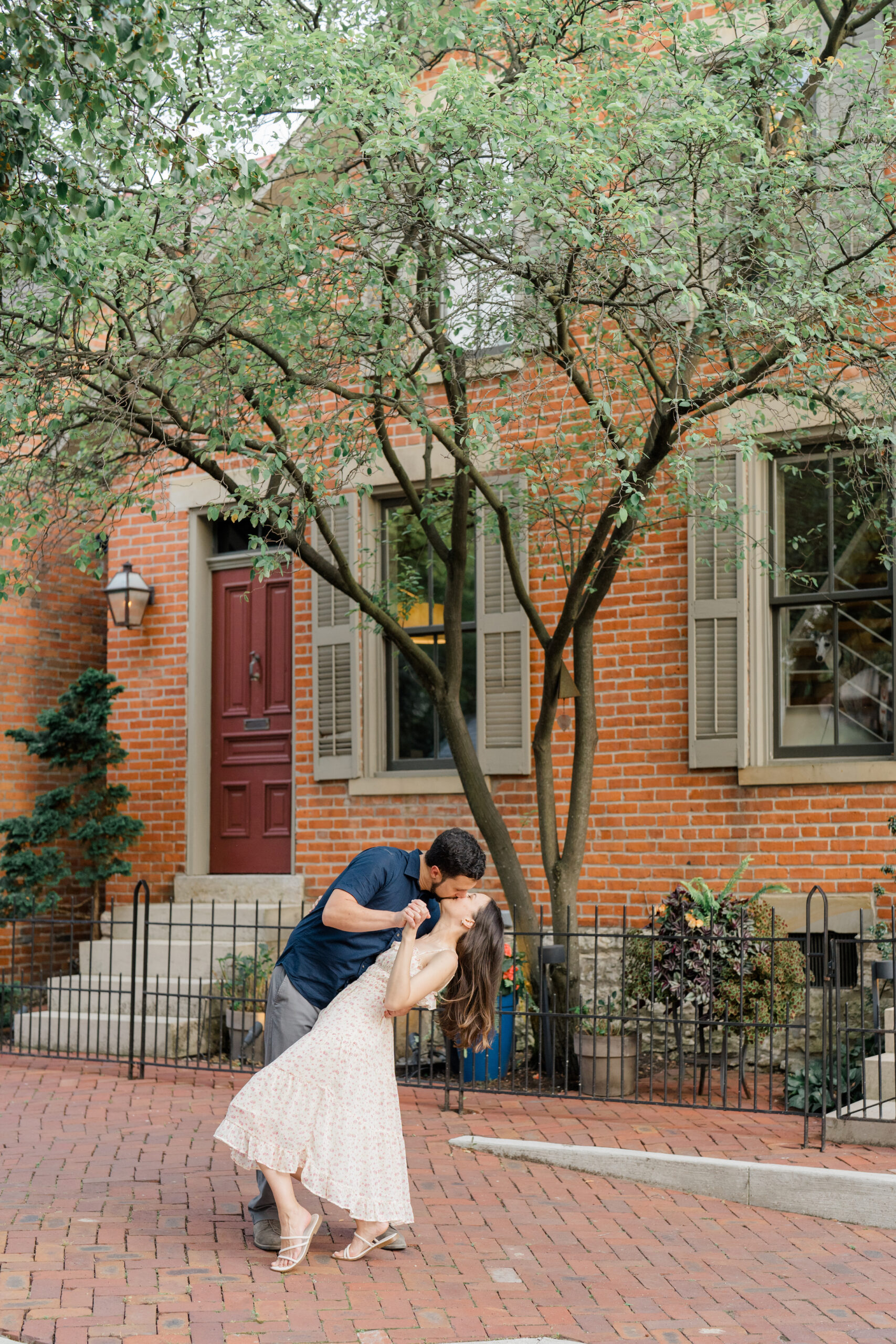 man dipping his girlfriend backward as they dance and kiss her passionately