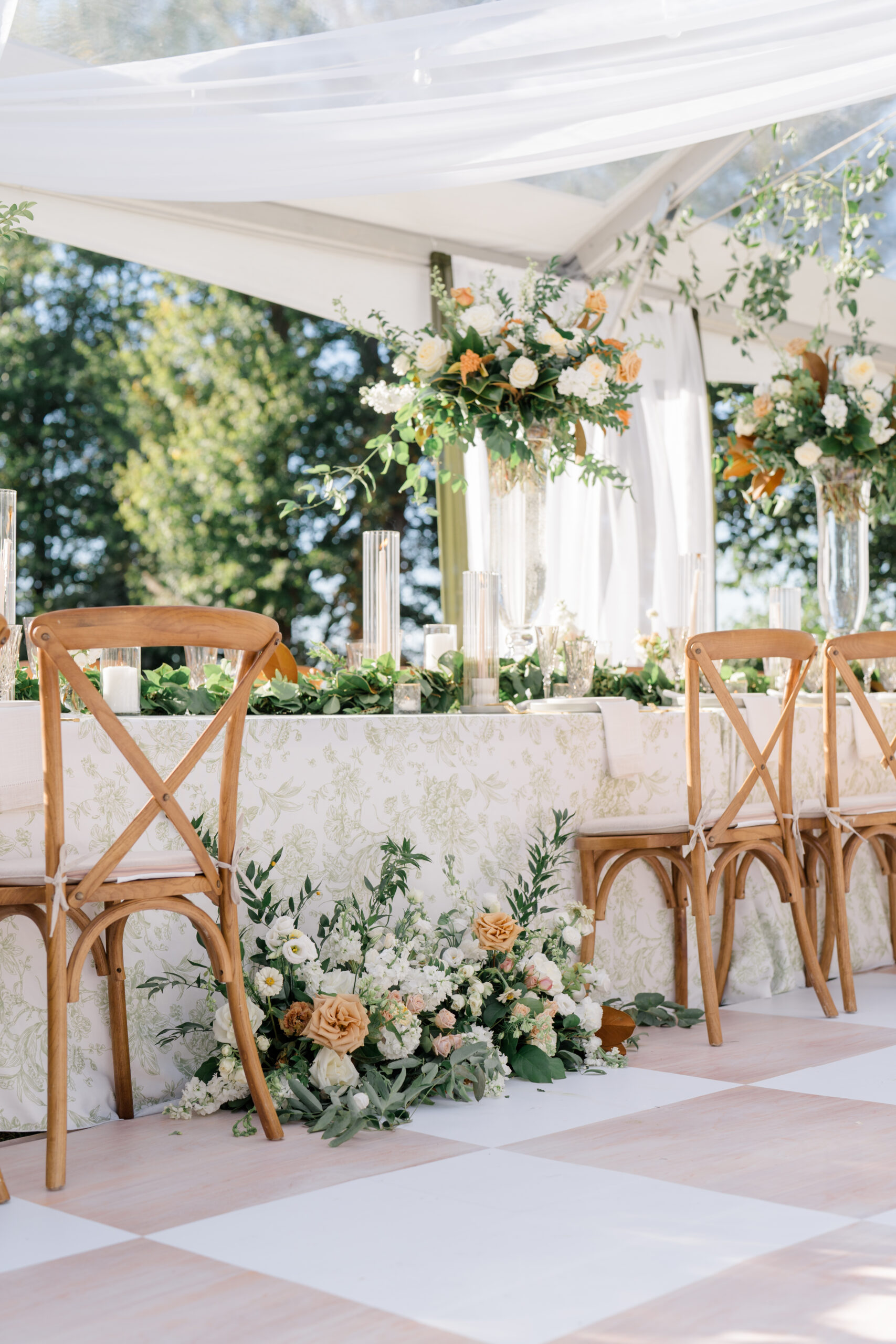 detail shot of floral arrangement that is sitting on the floor in front of the bride and groom's table in their white tent wedding reception in Ohio