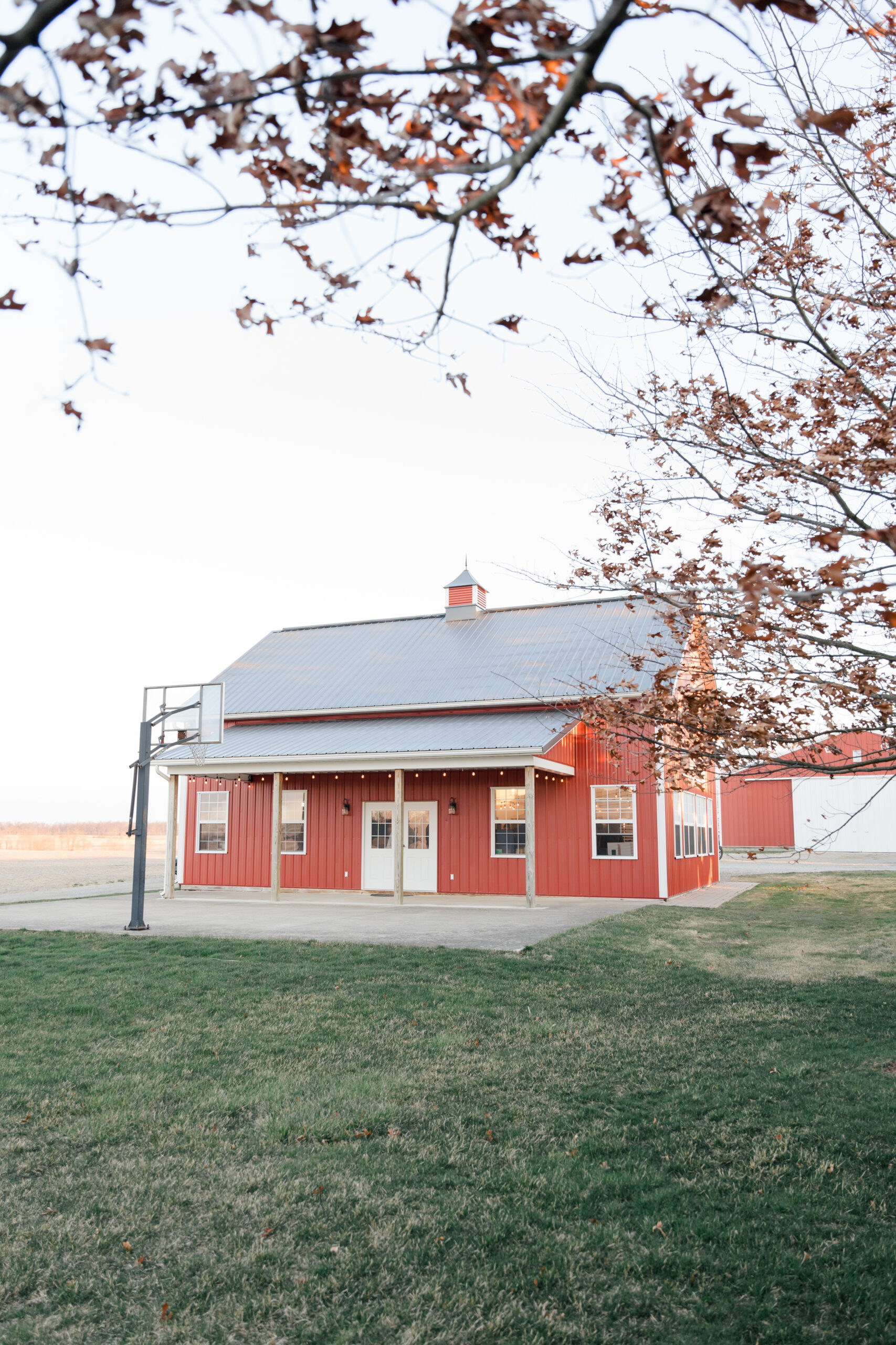 brand photographer captures red barn on an open field for commercial photography