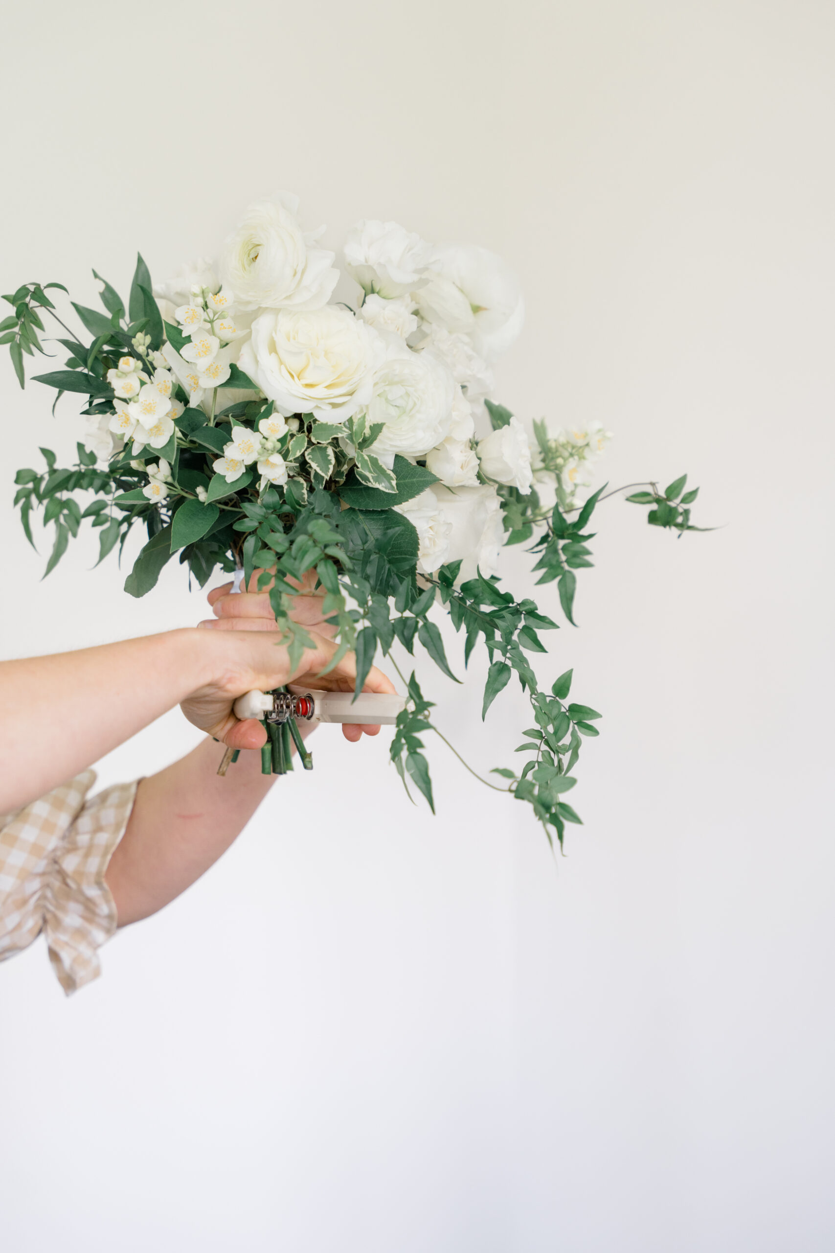 floral arrangement being held in front of a white backdrop captured by brand photographer in Columbus